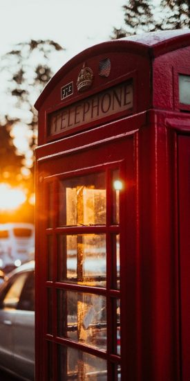 Photo of a red phone box from the UK with sun shining through from behind